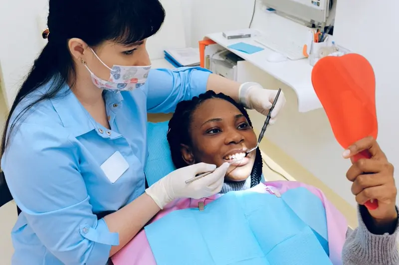 Paciente acompanhando o cuidado odontológico com espelho — imagem ilustrativa externa